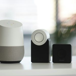 white and gray Google smart speaker and two black speakers